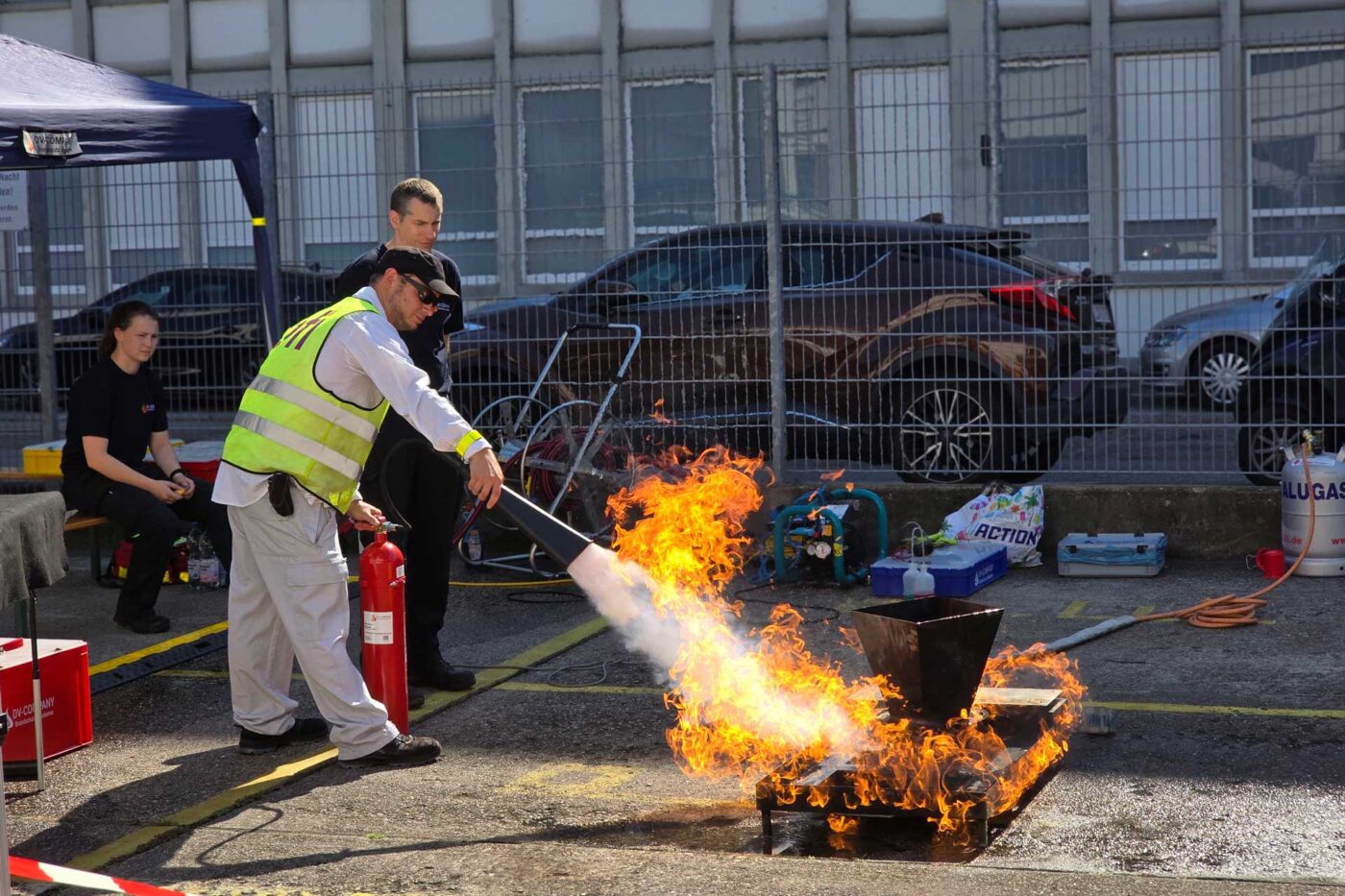 Teilnehmer übt bei den Ofi Safety Days 2025 den Einsatz eines Feuerlöschers. Unter Anleitung wird ein offenes Feuer realistisch bekämpft.