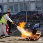 Teilnehmer übt bei den Ofi Safety Days 2025 den Einsatz eines Feuerlöschers. Unter Anleitung wird ein offenes Feuer realistisch bekämpft.